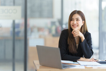 Attractive asia busy business woman consultant auditor working at modern office with balance sheet accounting bookkeeping documents. Account verification to prevent fraud bribery.