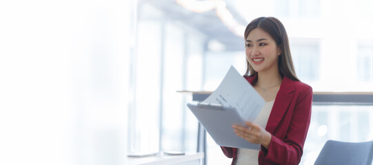 Attractive asia busy business woman consultant auditor working at modern office with balance sheet accounting bookkeeping documents. Account verification to prevent fraud bribery.