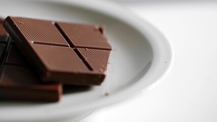 Carousel pieces of chocolate bar isolated on a white plate