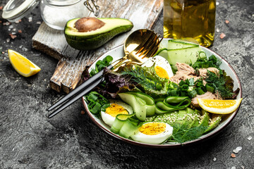 Tuna vegetable vegetarian buddha bowl avocado, egg, cucumber and fresh salad on a dark background. Long banner format. top view