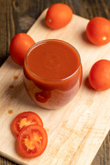 Fresh red tomato juice poured into a glass
