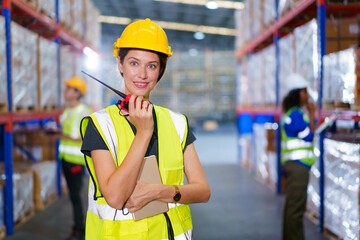 Happy cheerful caucasian white female warehouse worker checking an items or stock inventory in warehouse. Professional occupation in logistic industrial concept.