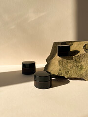 Amber cosmetic jar for cream, body lotion, face cleanser or hand cream  on a beige sandy background.