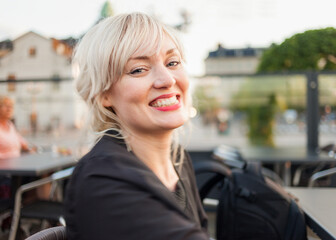 Spontaneous portrait of a happy and relaxed blond woman in the city