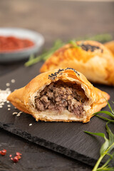 Homemade asian pastry samosa on black. side view, selective focus.