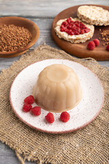 Buckwheat milk jelly on gray wooden, side view.