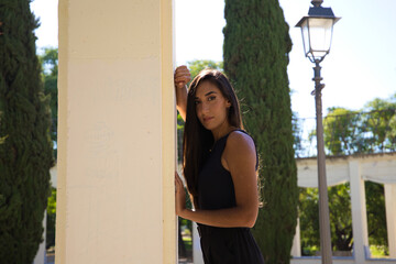 Spanish beautiful brunette woman posing for photo shoot. The woman is in the park lying on a park...