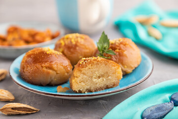 Traditional turkish dessert sekerpare with almonds and honey on gray concrete, side view, selective focus.