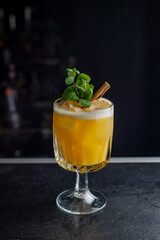 Yellow cocktail with foam on a dark background