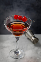 Gin and It cocktail in martini glass garnished with cherries. Martini alcoholic cocktail or non-alcoholic mocktail. Martinis.