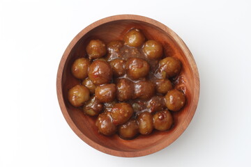 a close up of cilok. Made from tapioca flour and a delicious peanut sauce. served in wooden bowl isolated on white background.