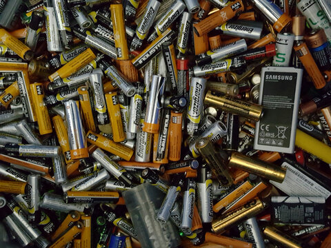Used batteries from different manufacturers, waste, collection and recycling, high danger for the environment. Batteries background