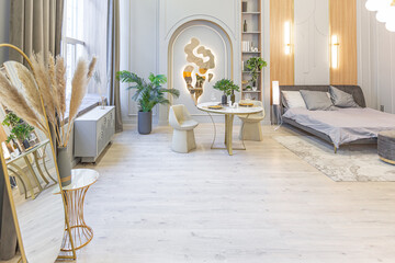 stylish luxury interior of modern studio apartment in green pastel colors with wooden elements. expensive furniture and decorations