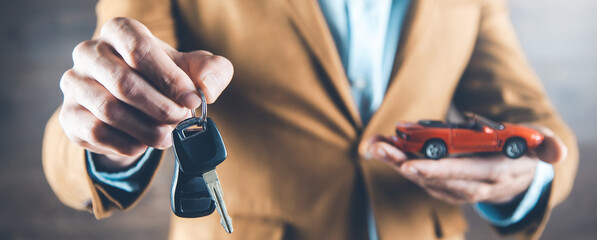 man hand car model with key  on dark background