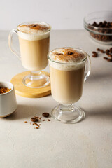 Two cups with coffee drink, latte or mocha with milk foam and cinnamon