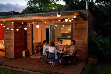 Happy couple friends enjoying dinner at summer patio table