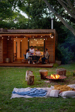 Couple friends enjoying dinner at patio table in summer backyard