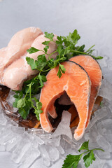 raw salmon steak with herbs and raw chicken breast on the wooden board on a gray rock background , raw ingredient for healthy diet, lunch, dinner, break7 uncooked frozen chicken and salmon