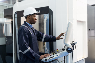African American male engineer worker working with CNC machine at production line in the industry...