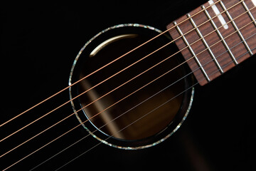 Guitar sound hole and strings shot from above in flat lay style. Beautiful black acoustic guitar in close up - obrazy, fototapety, plakaty