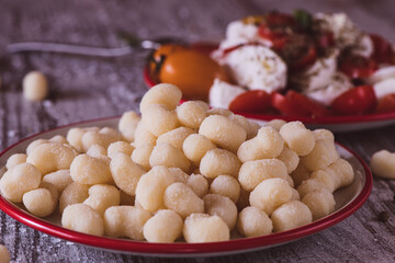 Raw gnocchi and Sorrentina sauce in the background