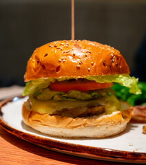 Organic vegetarian burger with plant based corn chicken burger, vegan cheese, green lettuce and baked potatoes