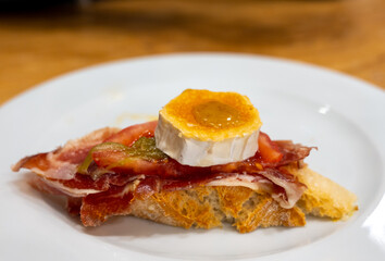 Board with typical snacks of Basque Country, pinchos or pinxtos, skewers or small piece of bread with toppings, served in bar in San-Sebastian or Bilbao, Spain