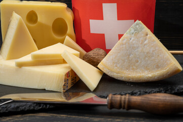 Assortment of Swiss cheeses Emmental or Emmentaler medium-hard cheese with round holes, Gruyere,...