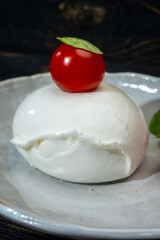 Сheese collection, one big ball on soft white italian mozzarella bufala cheese with red tomato and green basil leaves