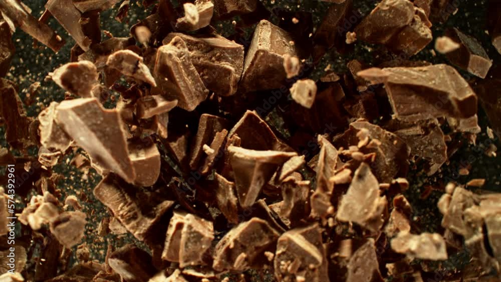 Poster super slow motion of rotating group of raw chocolate pieces. super fast camera motion. filmed on hig