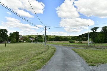 Route de campagne sous les cumulus de beau temps aux environs du bourg de Champagne au Périgord Vert  © Photocolorsteph
