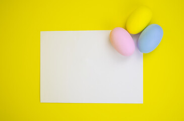 Easter template. White sheet with copy space on a yellow background and eggs. Concept for text, inscription, invitation, holiday, promotion, design,poster,decor,card, mock up, pattern,announcement.