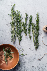 Fresh rosemary herbs still life on grey background, top view