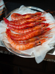 fresh raw red prawns on white paper on a tray ready for cooking