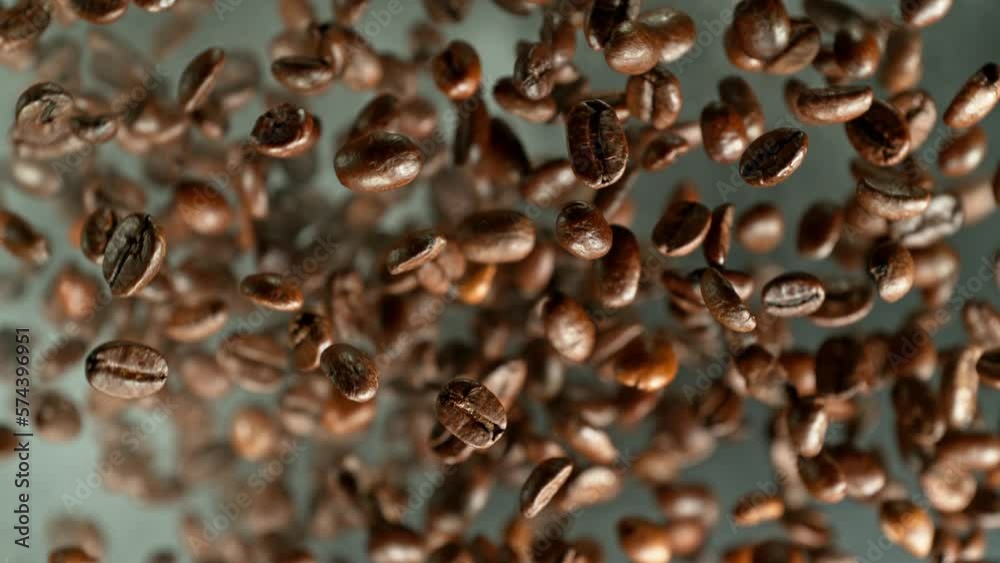 Poster Super slow motion of rotating coffee beans on black background. Filmed on high speed cinema camera, 1000 fps placed on high speed cine bot.  Camera moving up with rotation. Speed ramp effect.