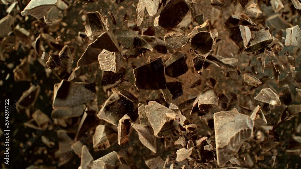 Poster super slow motion of rotating group of raw chocolate pieces. super fast camera motion. filmed on hig