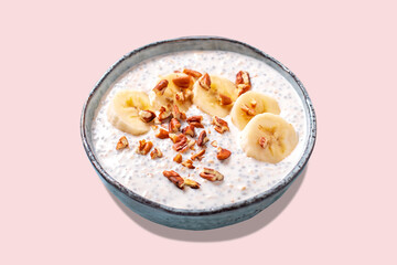 Banana and pecan nuts overnight oatmeal with chia seeds in bowl, rich in protein breakfast or snack
