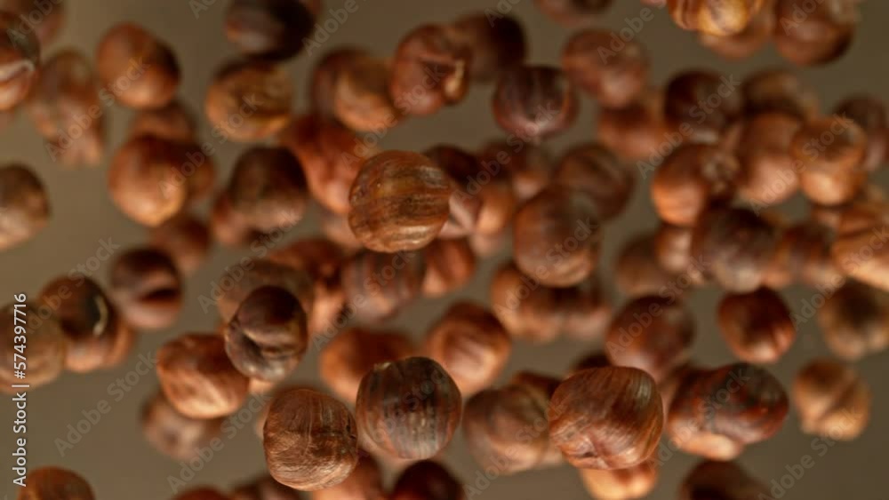 Poster super slow motion of rotating hazelnuts up to the air. filmed on high speed cinema camera, 1000fps, 
