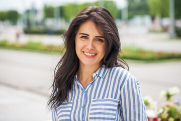 Young beautiful brunette girl in summer street