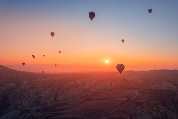 Amazing sunrise Cappadocia with set colorful hot air balloons fly in pink sky with first sun light. Turkey travel Concept, aerial view