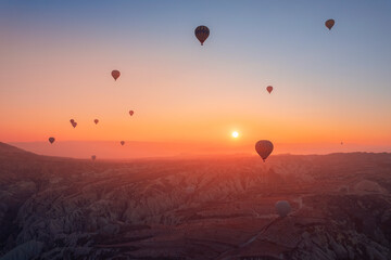 Amazing sunrise Cappadocia with set colorful hot air balloons fly in pink sky with first sun light. Turkey travel Concept, aerial view