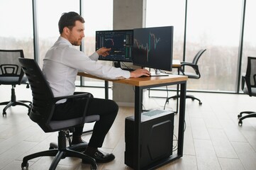 Serious business man trader analyst looking at computer monitor, investor broker analyzing indexes, financial chart trading online investment data on cryptocurrency stock market graph on pc screen.
