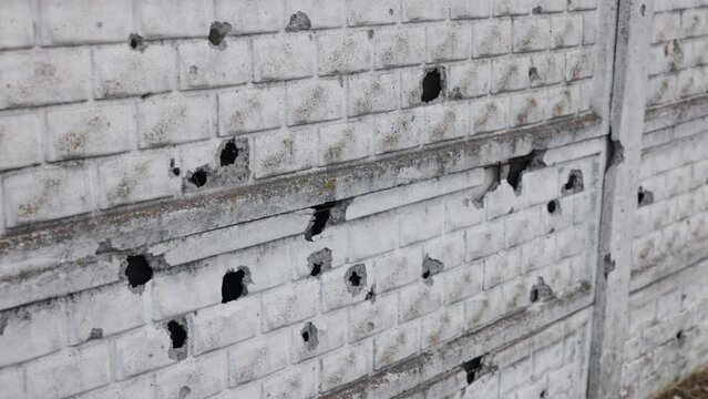 Hole wall, Damaged surface, concrete fence. Concrete fence in ukraine was destroyed by bullets or shelling, was left with bullet and shell holes