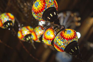 Fototapeta na wymiar Turkey market with many traditional colorful Turkish handmade lamps and lanterns. Popular souvenirs from Turkey, selective focus on lantern, blurred background