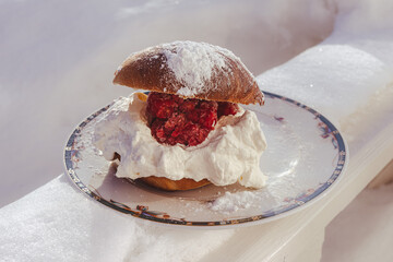 bun with cream, raspberries and flour