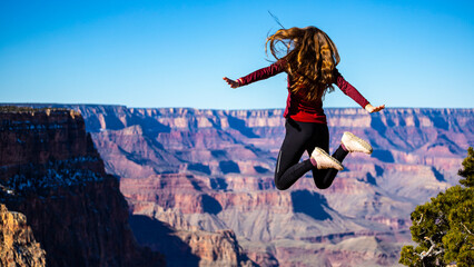 happy hiker girl jumps for joy in grand canyon national park, flying above grand canyon, arizona,...