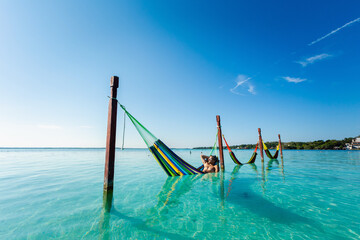 Man on hammock in Bacalar lagoon Mexico - obrazy, fototapety, plakaty