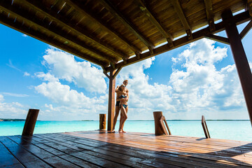 Couple relaxing on a pier Bacalar lagoon Mexico - 574407530