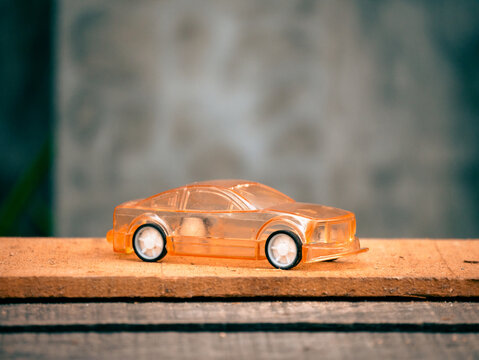 A Photo Of A Transparent Orange Toy Car