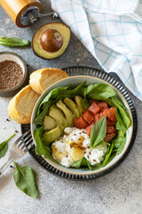 Classic breakfast, brunch - with poached egg, avocado, arugula, flax seeds and salted salmon on a gray background.